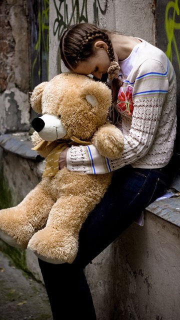 A girl cry on teddy shoulder